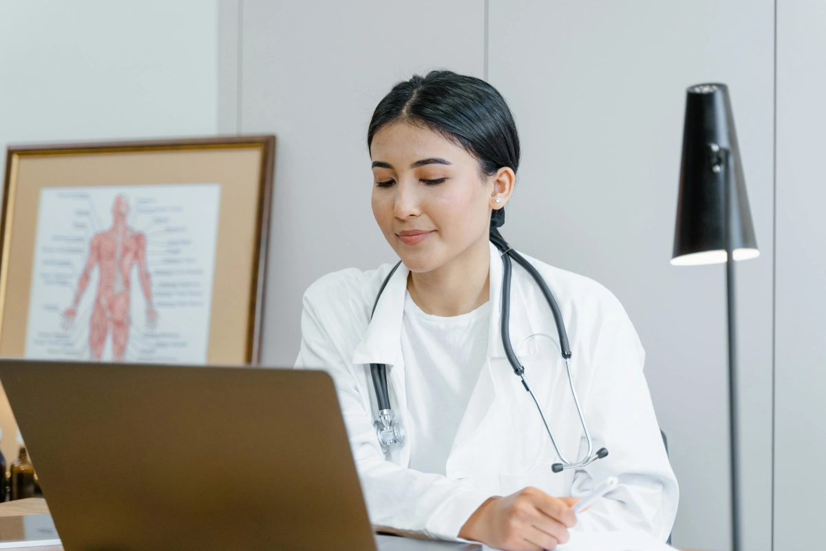 Médica internista realizando una consulta en línea frente a su computadora, representando el enfoque en el diagnóstico y tratamiento en Medicina Interna.