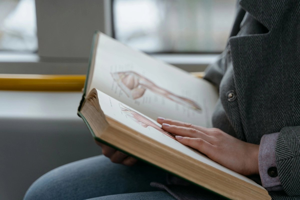 Estudiante de medicina leyendo un libro médico.