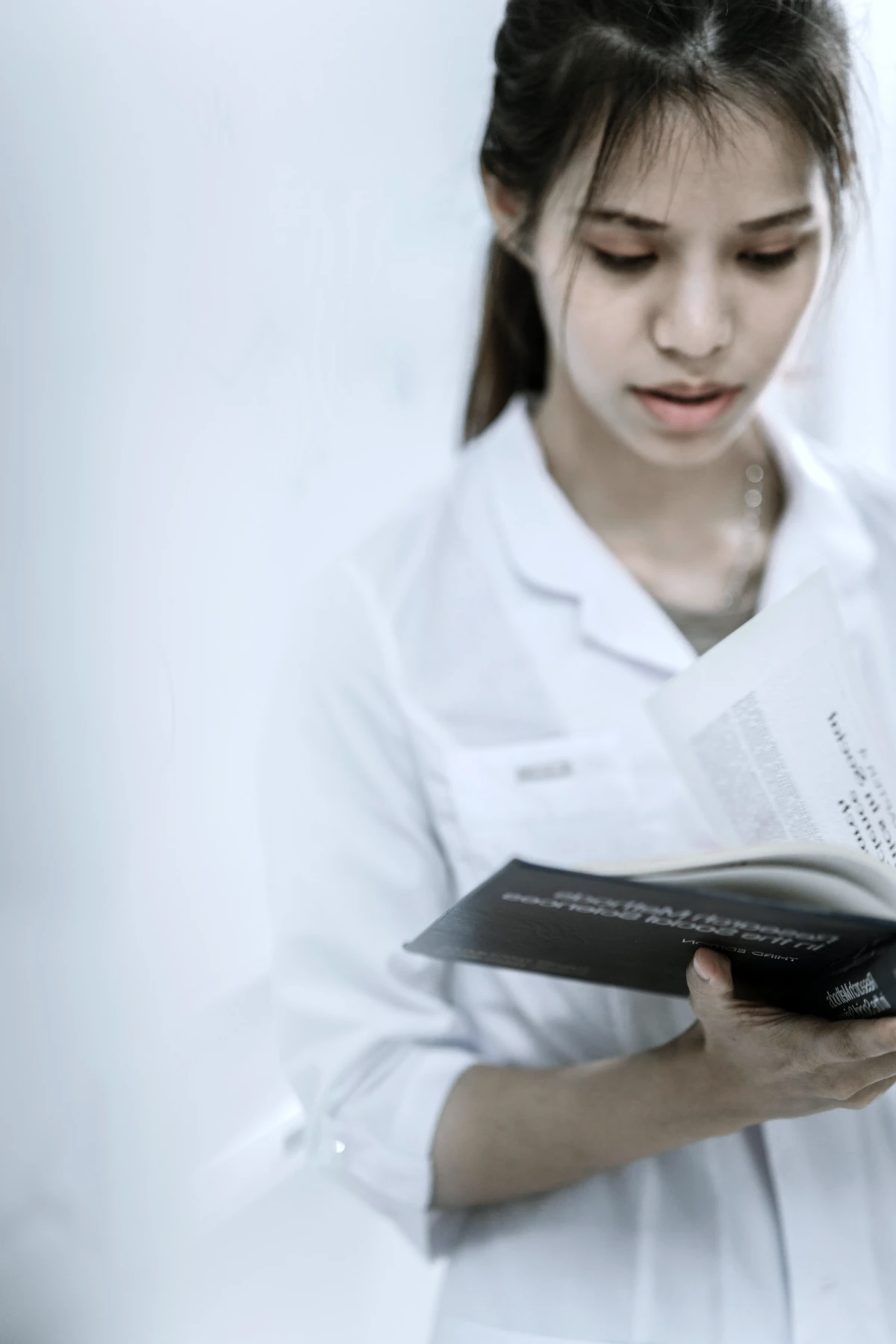 Estudiante de medicina revisando notas en un libro, simbolizando la preparación para el examen CACES en Ecuador.